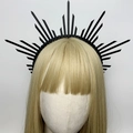 Dettaglio di cerchietto nero con punte a corona su un manichino dai capelli biondi - Stile 4