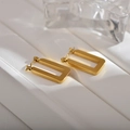 Details von matten goldenen rechteckigen Creolen auf weißen Stufen mit Glasakzenten - Minimalistische Rechteckige Creolen / Gold Gebürstetes Rechteck