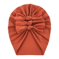 Detail of reddish-brown baby cotton turban with three decorative bows on white background - Dark Orange