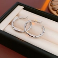 Dettaglio di orecchini a cerchio in argento martellato su un astuccio per gioielli nero - 9# Silver Earring Post cerchi irregolari con texture martellata