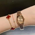 Elegant gold oval watch with red clover bracelet set worn on wrist for fashion - Metal Elastic Strap / Rose Gold
