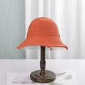 Women's hand-knitted orange bucket hat with wide brim on a wooden display stand - M (56-58cm) / Orange Red