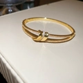 Gros plan d'un bracelet nœud plaqué or serti de micro-pavés étincelants en zircone - Design de Nœud / Or