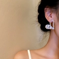Close-up of heart-shaped silver earrings with sparkling crystals worn by a model - Silver Heart