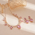 Gros plan d'un ensemble de bijoux en zircon rose en forme de goutte plaqué or chic - Rose