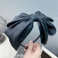 Detailed close-up of a large black triple-layer satin bow headband with a glossy finish - Pure Black