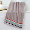 Gray cotton face towel with colored stripes and checkerboard edge on a white sink - Digital Grey Towel