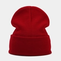 Close-up of vibrant red knit beanie showing tight fabric texture and folded cuff detail - Burgundy