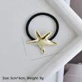 Detail of golden starfish hair tie showing 5x4cm dimensions and 9g weight on white tray - Gold Glossy Starfish