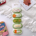 Vue détaillée des barrettes tricotées à la main avec fleurs et fruits sur support - Style Marguerite/Fleur / Ensemble Vert