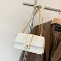 Detail of white crocodile embossed texture on crossbody bag with gold rotating lock - White