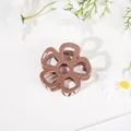 Detailed top view of a brown flower claw clip with a minimalist hollow floral design - Hollow Five-Petal Flower - Glossy Brown