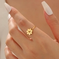 Elegante anello a margherita dorato in acciaio inossidabile indossato con dettagli floreali - Anello Margherita Oro