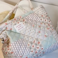 Gros plan du sac fourre-tout en coton matelassé avec motifs floraux et étiquette en tissu - Beige avec motif floral géométrique