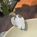 Haarklammer aus Acetat mit Siamkatzen-Muster auf einer Keramikschale auf Holztisch - Weiße Ragdoll Katze