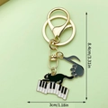 Schattige zwarte emaille kat sleutelhanger met pianotoetsen en muzieknoten in goud - Pianonoot Kat (LS213) / 8.4x3cm