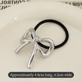 Silver metallic bow hair tie with textured finish on white ceramic tray background - Bowknot Silver