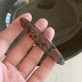 Fermaglio per capelli lungo in acetato ambrato con motivo tartarugato tenuto in mano - Fermagli per capelli a becco d'anatra / Tartarugato Blu Ovale