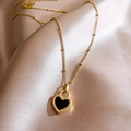 Elegant gold beaded chain bracelet featuring a black heart charm on champagne silk fabric - Knotted Heart Necklace