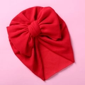 Detailed view of soft red knit baby turban hat featuring a large decorative bow - Red