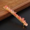 Detailed shot of handmade pink crystal stones wrapped with gold wire on a hairpin - Watermelon Quartz + Gold Clip