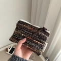 Hand holding a colorful woven mini pouch with zipper and simple brand label - Brown Striped Tweed