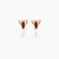 Macro detail of gold lobster stud earrings with red crystal gems and mirrored reflection - Lobster
