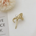Elegant gold metal ear cuff featuring a geometric cross design with a white pearl accent - Gold