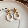 Detailed shot of gold metal studs with white resin drop pendants on a ceramic plate - Gold Cream Geometric (9# Silver Needle)