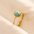 Close-up of golden adjustable ring featuring a turquoise stone and textured metal band - Gold Base-Light Blue Stone
