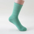 Light green cotton yoga socks with grey anti-slip silicone dots on model foot - One Size / Green