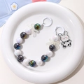 Dettaglio catena di perle per borraccia con ciondolo a coniglio in piatto bianco - Nero Bianco Iridescente-Coniglio Mucca