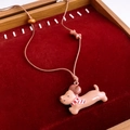 Gros plan détaillé d'un pendentif chiot teckel marron sur un écrin en velours rouge - Style Teckel à l'Écharpe (WN2062)