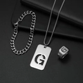 Detail eines silbernen Titanstahlschmucksets mit hohlem G-Anhänger und Siegelring - Set G