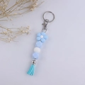 Dettaglio del portachiavi con perline di silicone blu e bianco con fiore e nappa - Blu