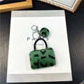 Detailaufnahme des Leoparden-Kunstfell-Minibags mit silbernem Karabinerhaken Anhänger - Grün