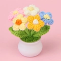 Nahaufnahme der handgefertigten gehäkelten Puffblumen-Topfpflanze aus buntem Garn - 5-farbig gemischte Pofblumen-Topfpflanze (weißer Topf)