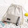 Creamy white canvas drawstring backpack with fashion patch and a front zipper pocket - White