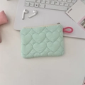Mint green quilted heart mini pouch with pink zipper loop on a clean office desk - Heart Green