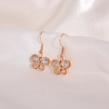 Close-up of rose gold butterfly earrings with clear zircons on white silk background - Rose Gold