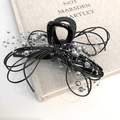 Detail of black ribbon hair claw clip featuring silver bead chain and leather cord texture - Black Bow Claw Clip