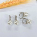 Close-up of U-shaped pearl earrings with cubic zirconia inlay on a white background - Silver