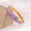 Detail of gold titanium bracelet with purple marquise-cut zircons on silk background - Purple
