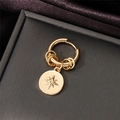 Detailed shot of golden hoop earring featuring an octagonal star pendant on velvet - Gold Without Diamond / Single Piece