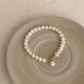 Baroque natural pearl bracelet with golden clasp on a ceramic plate, elegant jewelry detail - Classic Freshwater Pearl Bracelet
