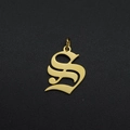 Close-up of golden stainless steel letter S pendant with ring on black texture - S