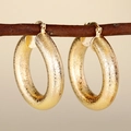 Eleganti orecchini a cerchio dorati spessi con finitura opaca testurizzata appesi a un ramo - E4426 Smerigliato Opaco / Oro