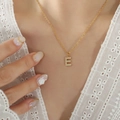 Gouden titanium ketting met een zirkonia letter E hanger aan een fijne ketting - Letter E Goud (RP016-E)