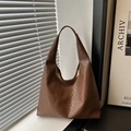 Bruine gevlochten shopper voor dames met grote capaciteit in een minimalistische setting - koffiekleur