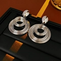 Pendientes de aros concéntricos plateados sobre estuche de cuero negro liso - Plateado